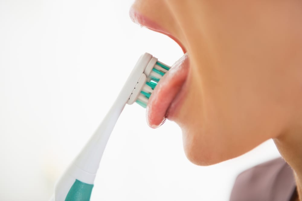 young woman cleaning her tongue