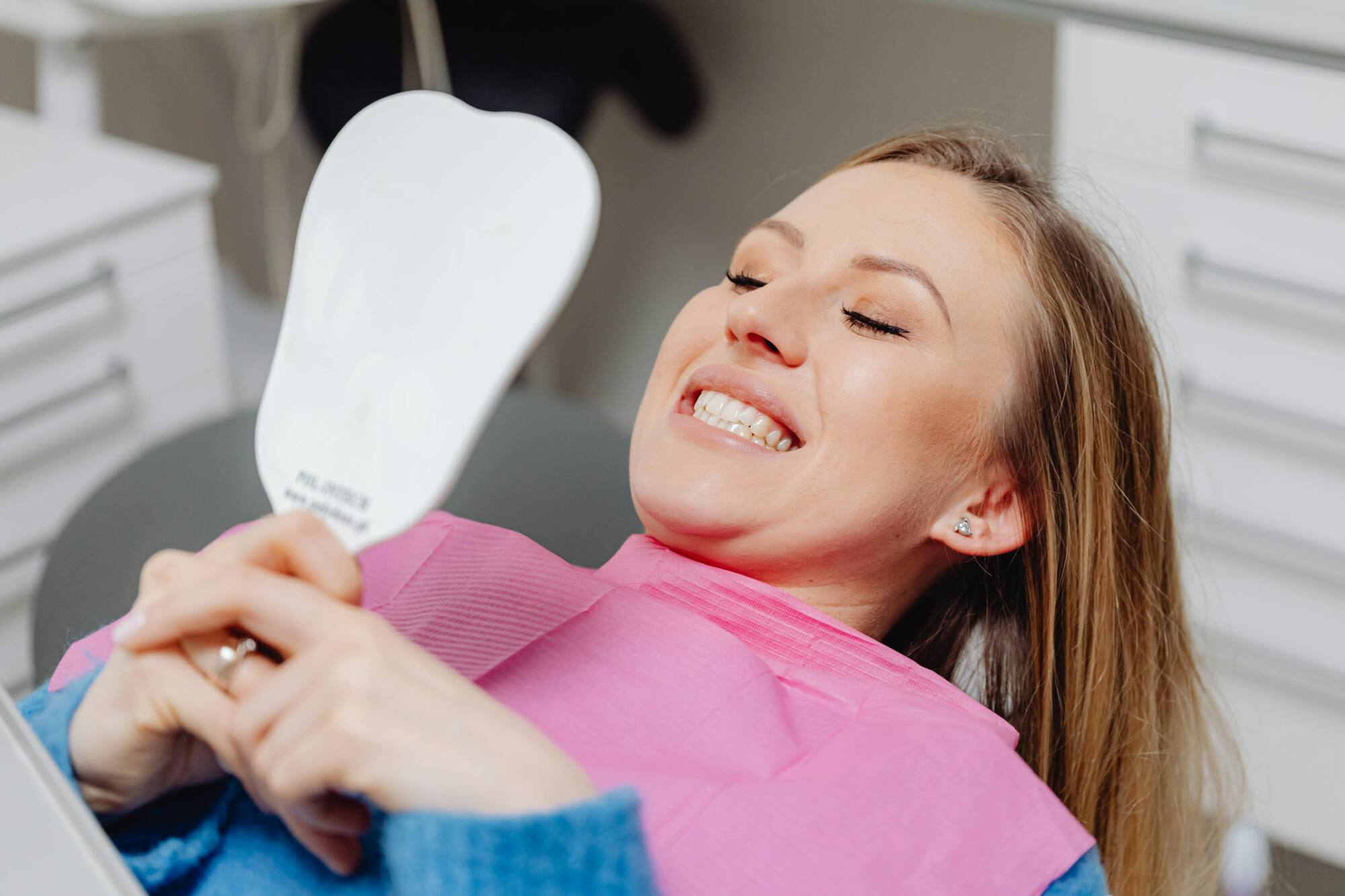 woman carrying mirror to see teeth